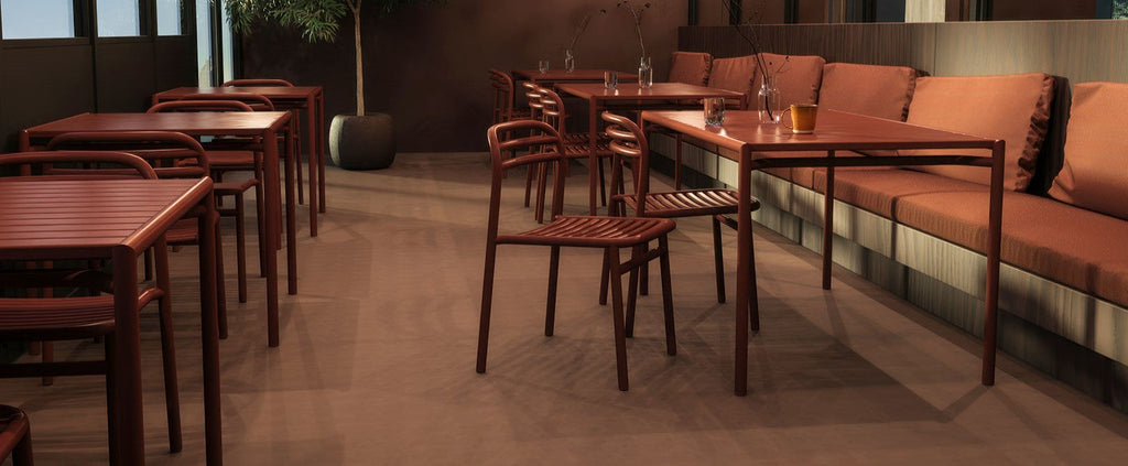 Desert red Bliss dining chairs and tables arranged in a stylish restaurant setting.