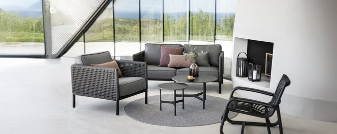 Modern lounge area with a grey sofa, black armchair, and round coffee table.