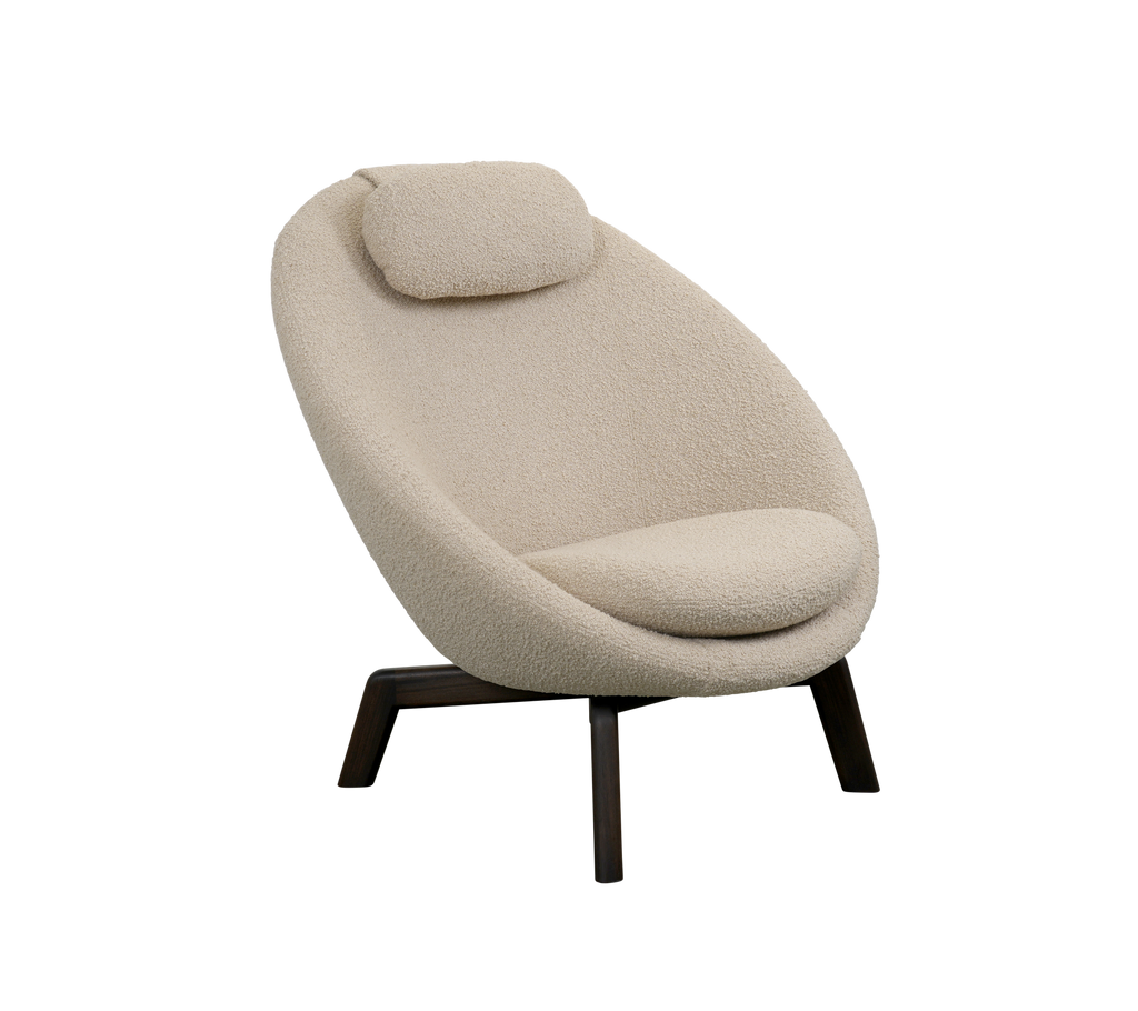 Contemporary upholstered chair with a rounded design, plush seat cushion, and a matching headrest, supported by slender wooden legs.