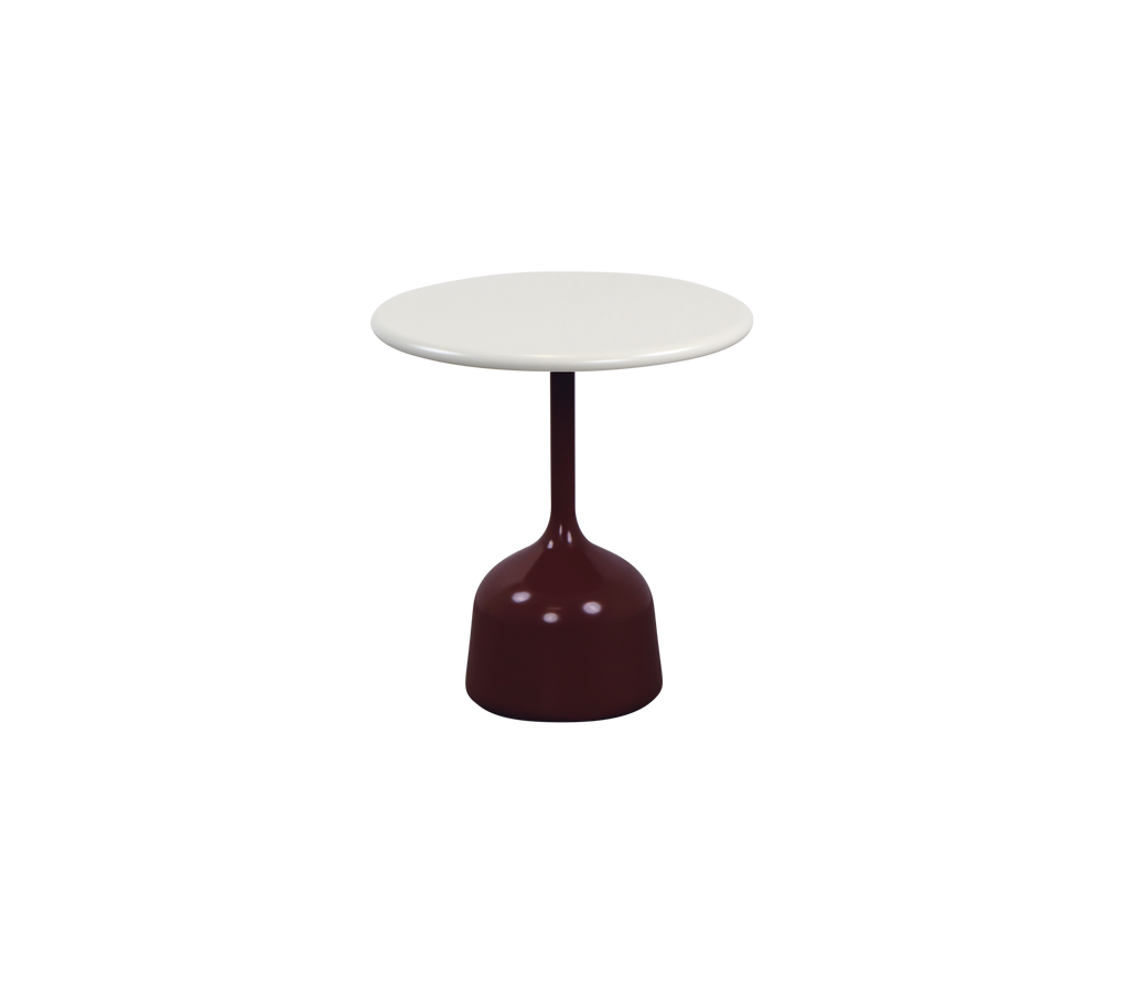 Modern burgundy table with a white tabletop in a lounge setting.