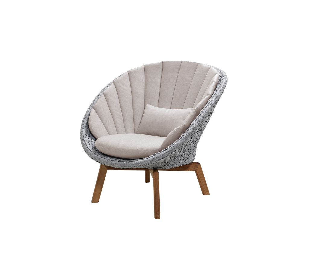 Modern light grey chair with sand cushion in a lounge setting.