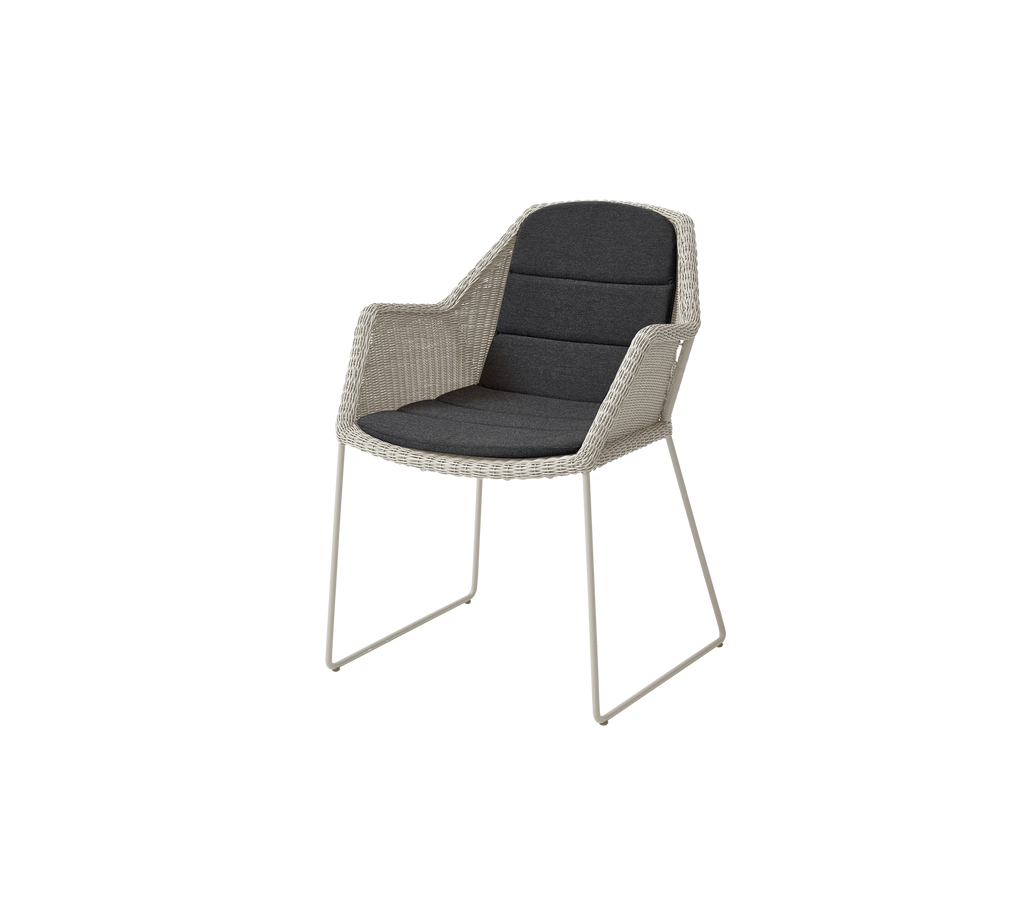 Modern chair with a black cushion and a light sand-colored frame.