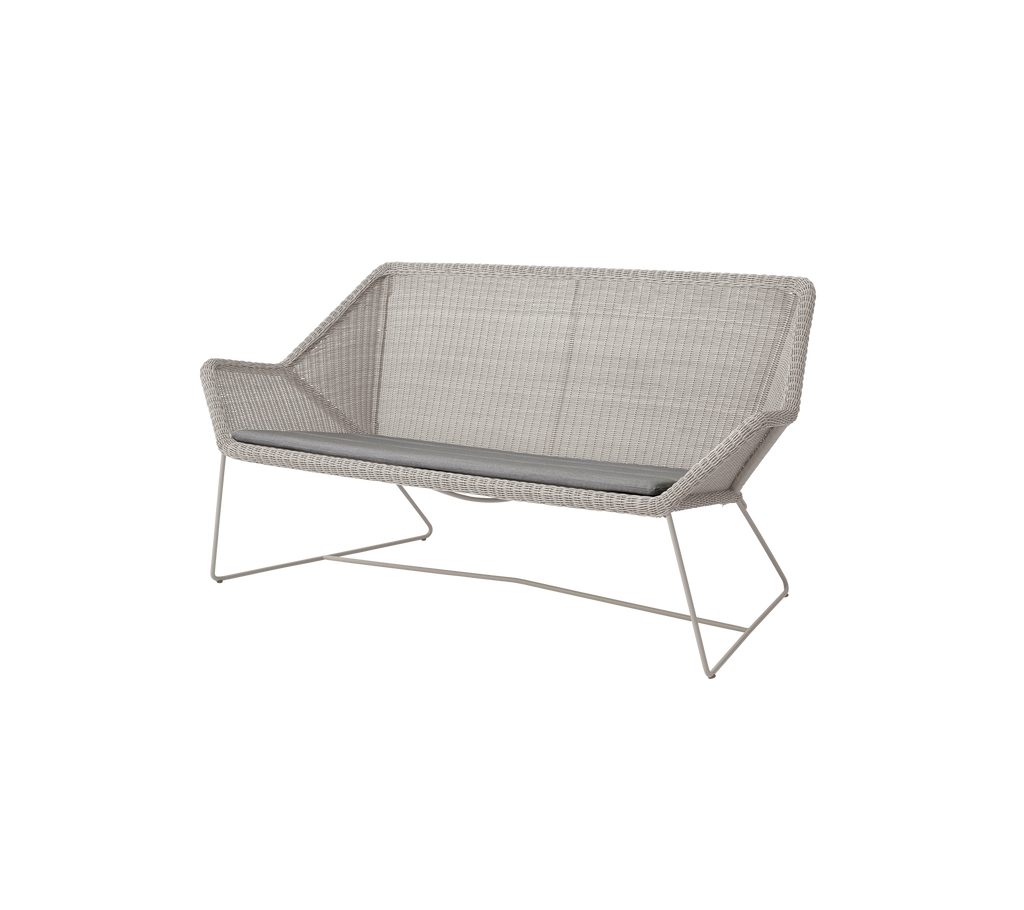 Modern grey loveseat with a sleek design in a contemporary setting.