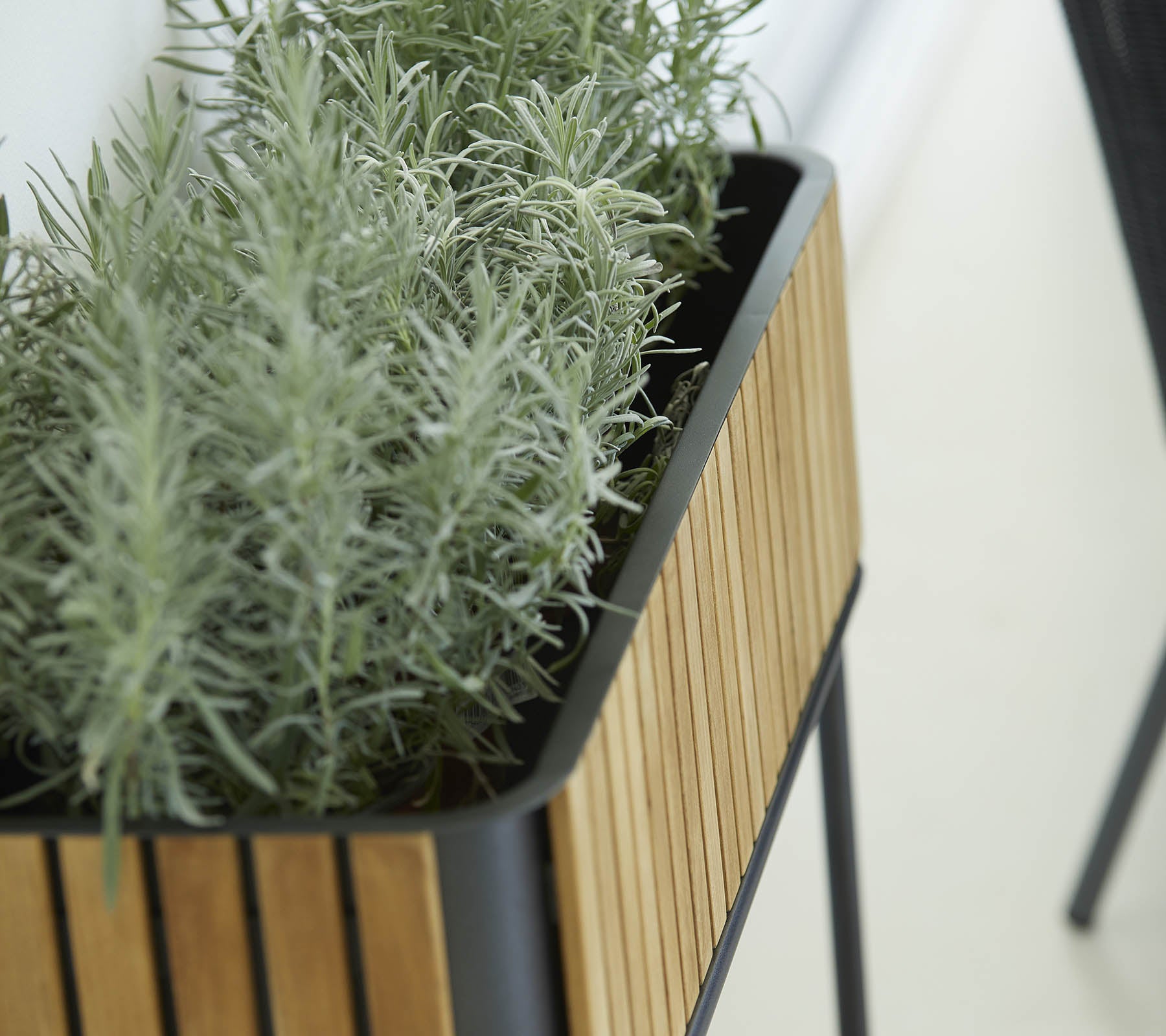 Planter with a sleek design featuring a wooden slat exterior and lush green plants, adding a touch of nature to the surroundings.