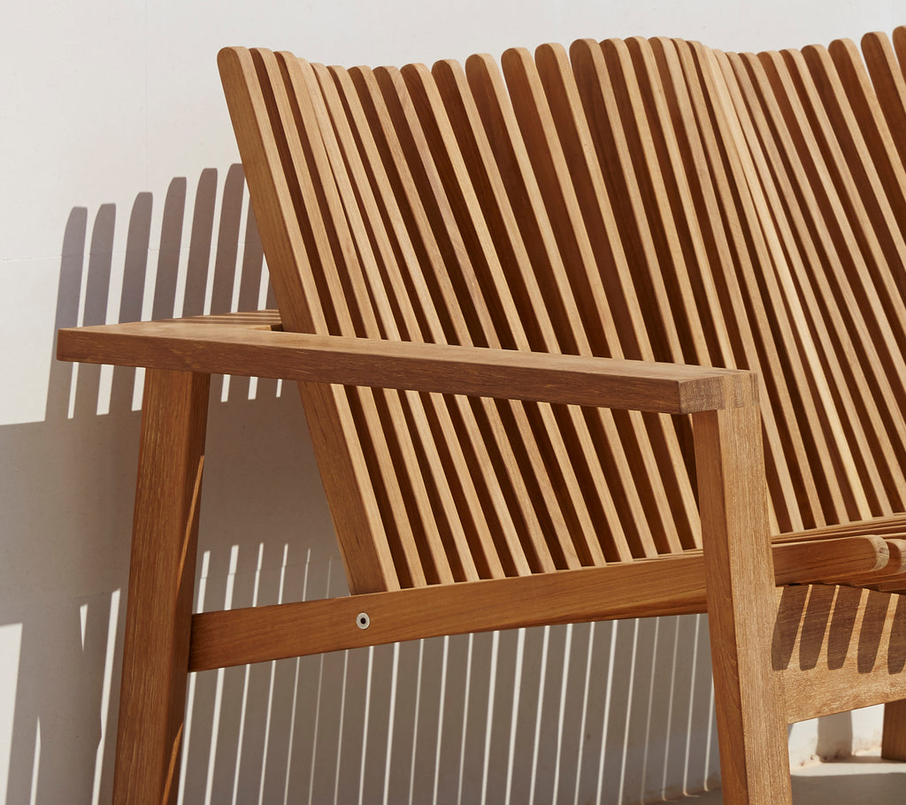 Side view of a stylish 2-seater sofa featuring a slatted backrest and wooden armrests, showcasing a modern design.