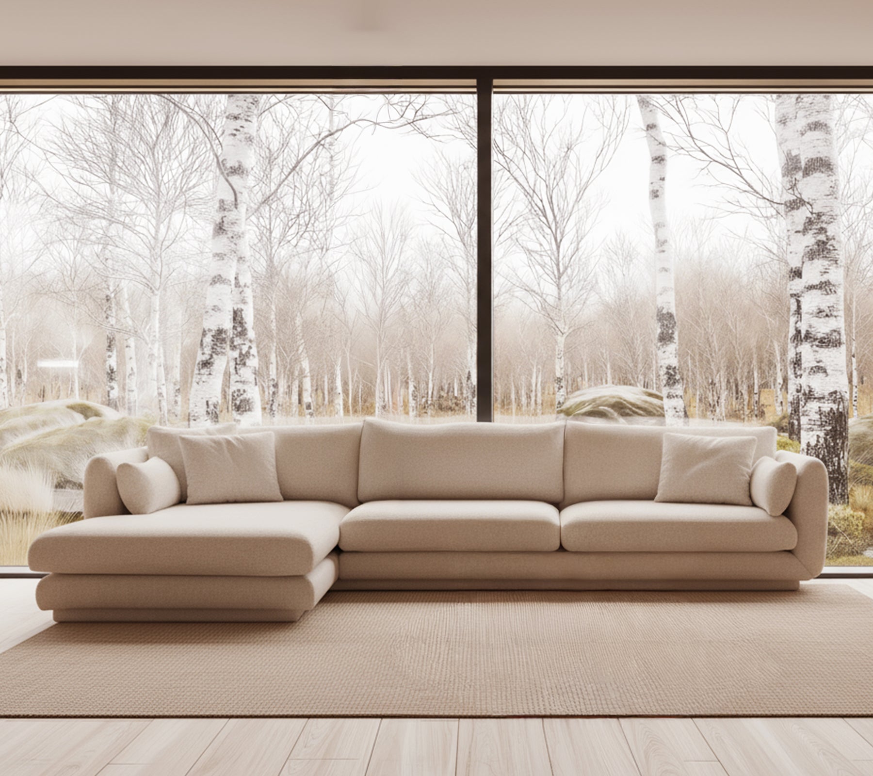 Beige modern sofa in a bright lounge setting with large windows.