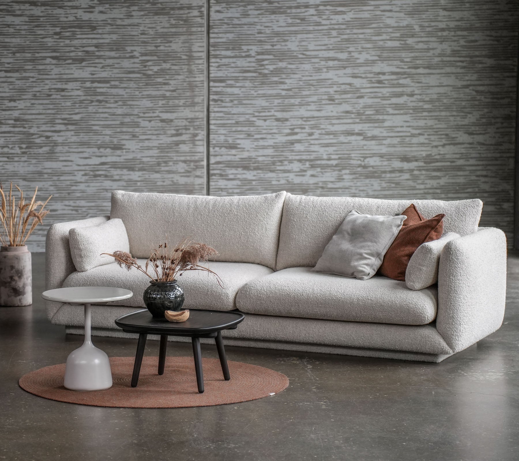 A stylish seating area featuring a light-toned sofa, a round coffee table, and decorative elements in soft colors.