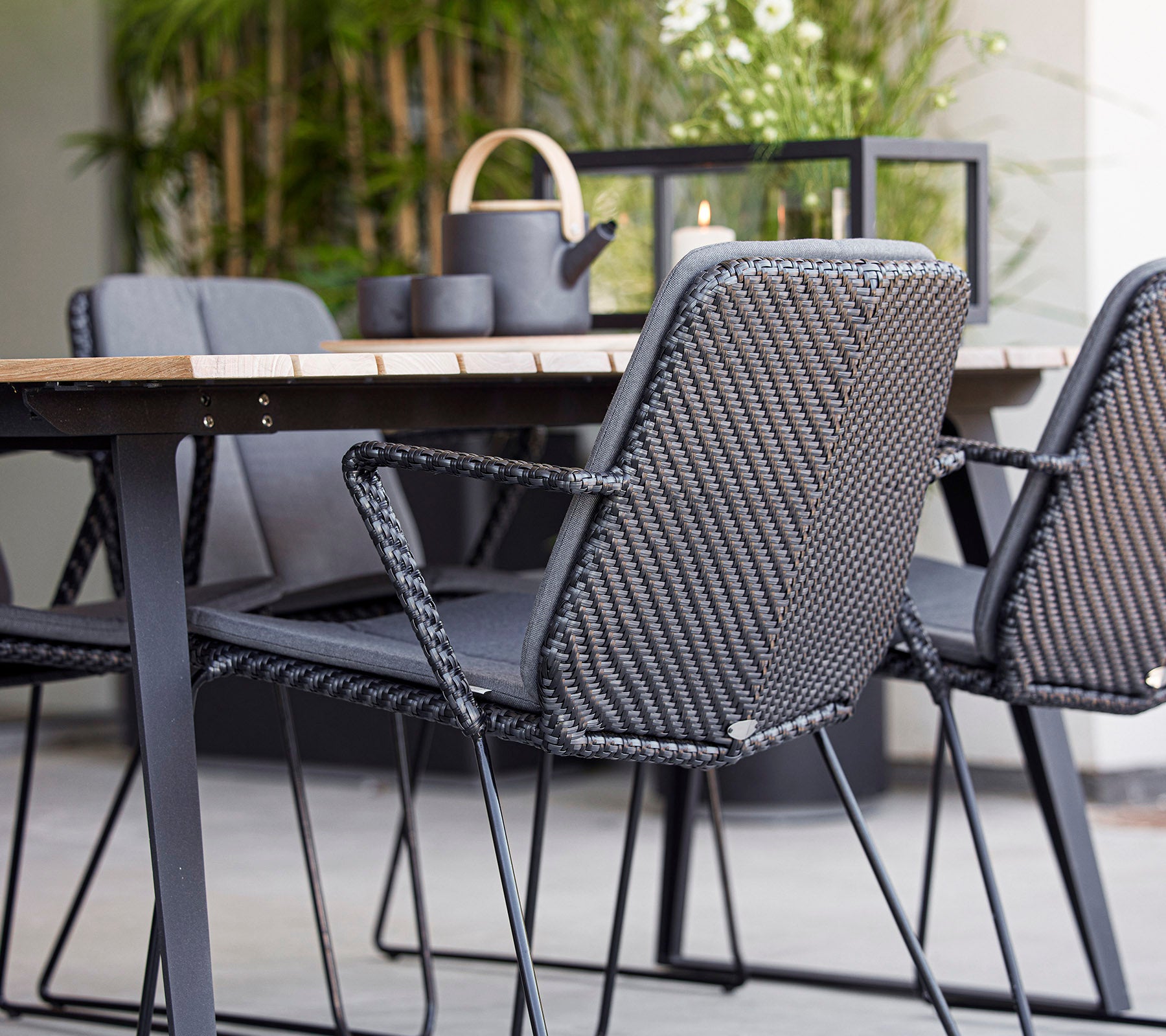 Contemporary seating with gray woven chairs around a wooden table, complemented by decorative items in a stylish arrangement.