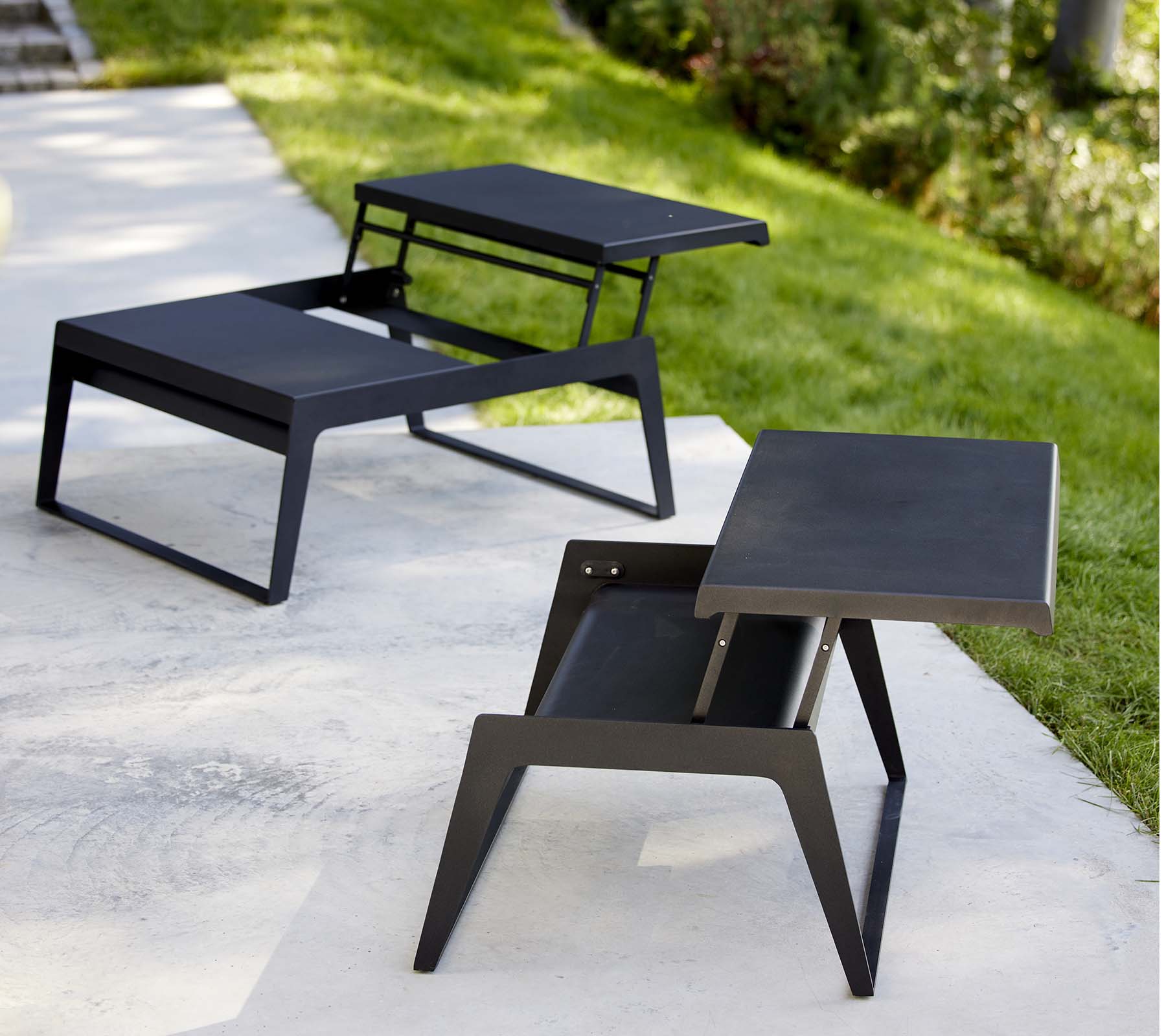 Two modern chill-out coffee tables with sleek designs and minimalist black finishes, showcasing versatility in style and functionality.