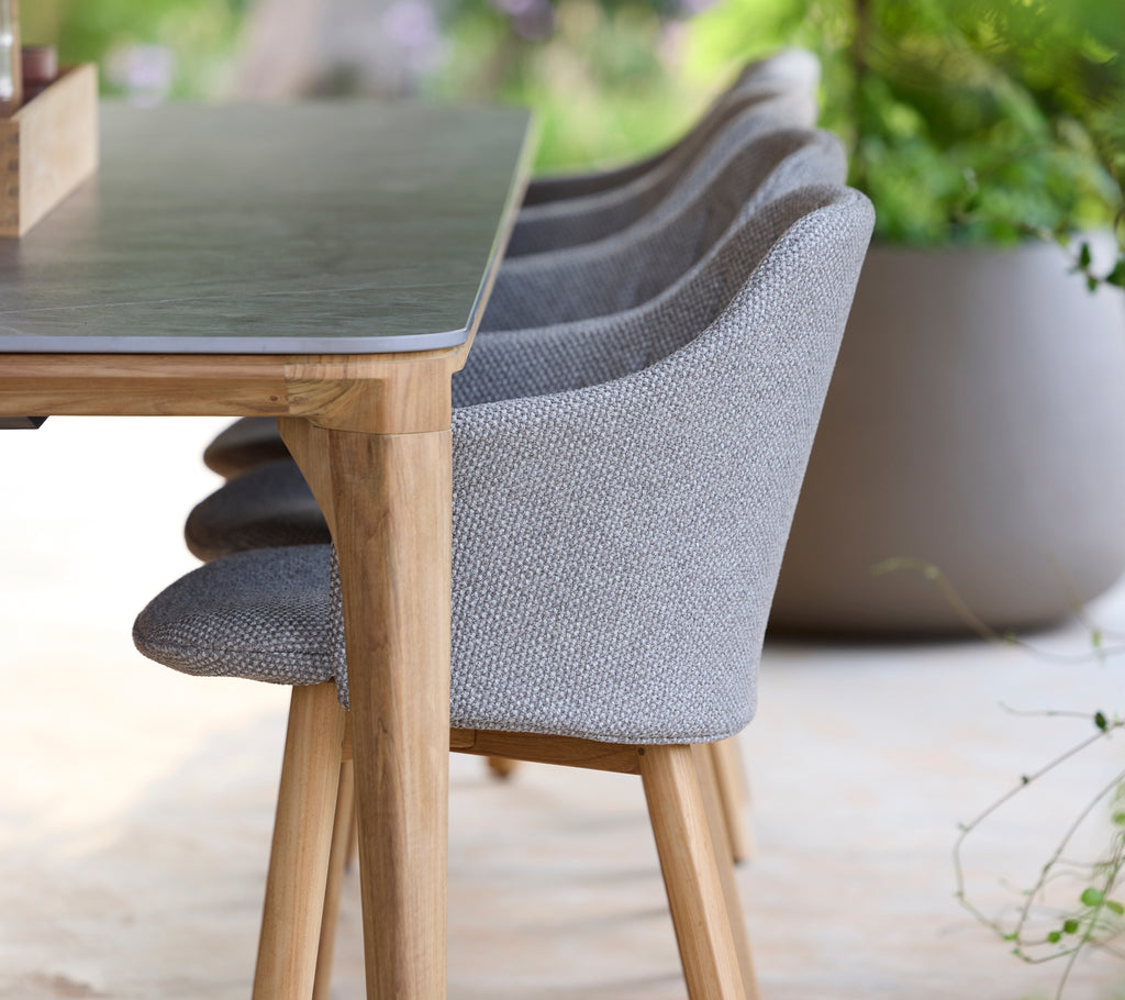 Modern grey chair and table in a serene outdoor setting.
