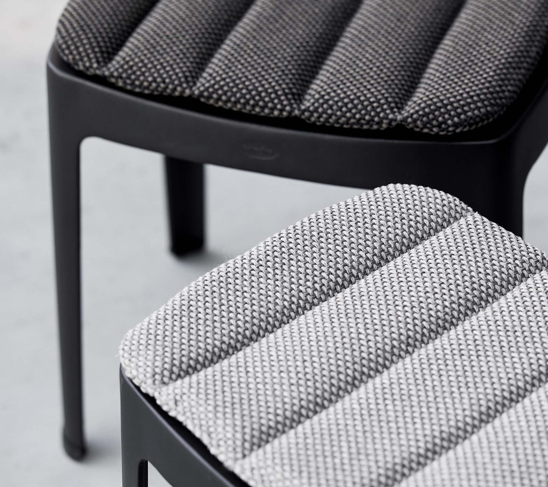 Two stylish stools featuring textured upholstery in contrasting shades of gray, showcasing a modern design with sleek lines.