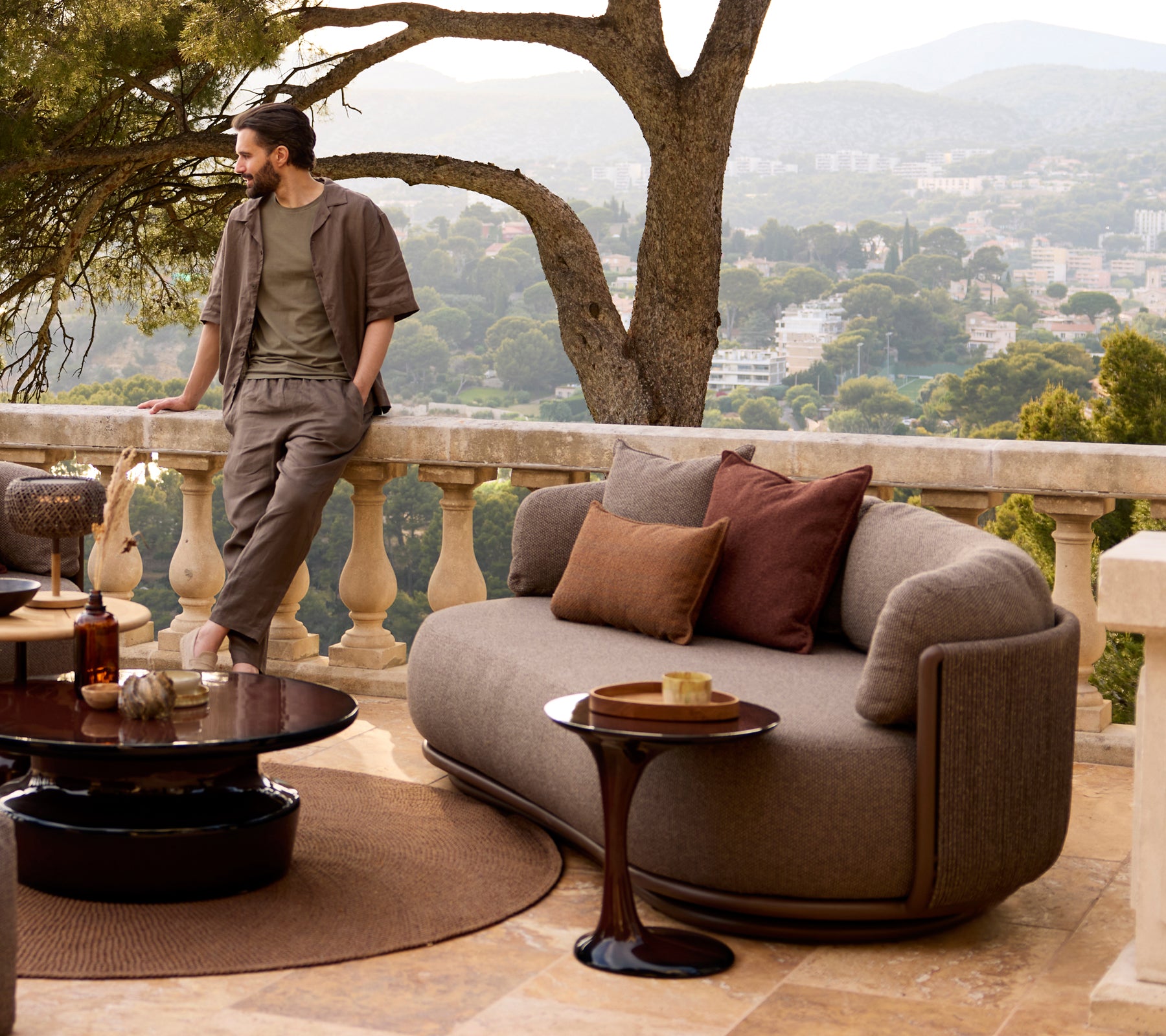 Grey sofa with brown cushions and a black coffee table in a modern lounge setting.