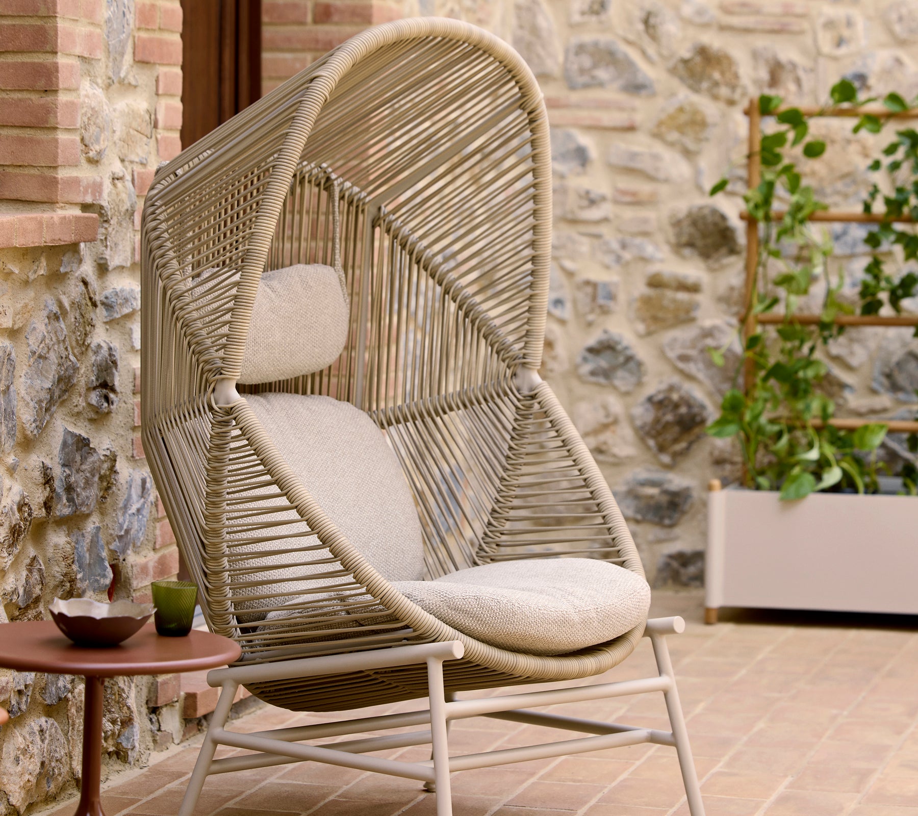 Hive chair in sand color features a unique woven design with plush seating and a distinctive overhead arch for comfort and style.