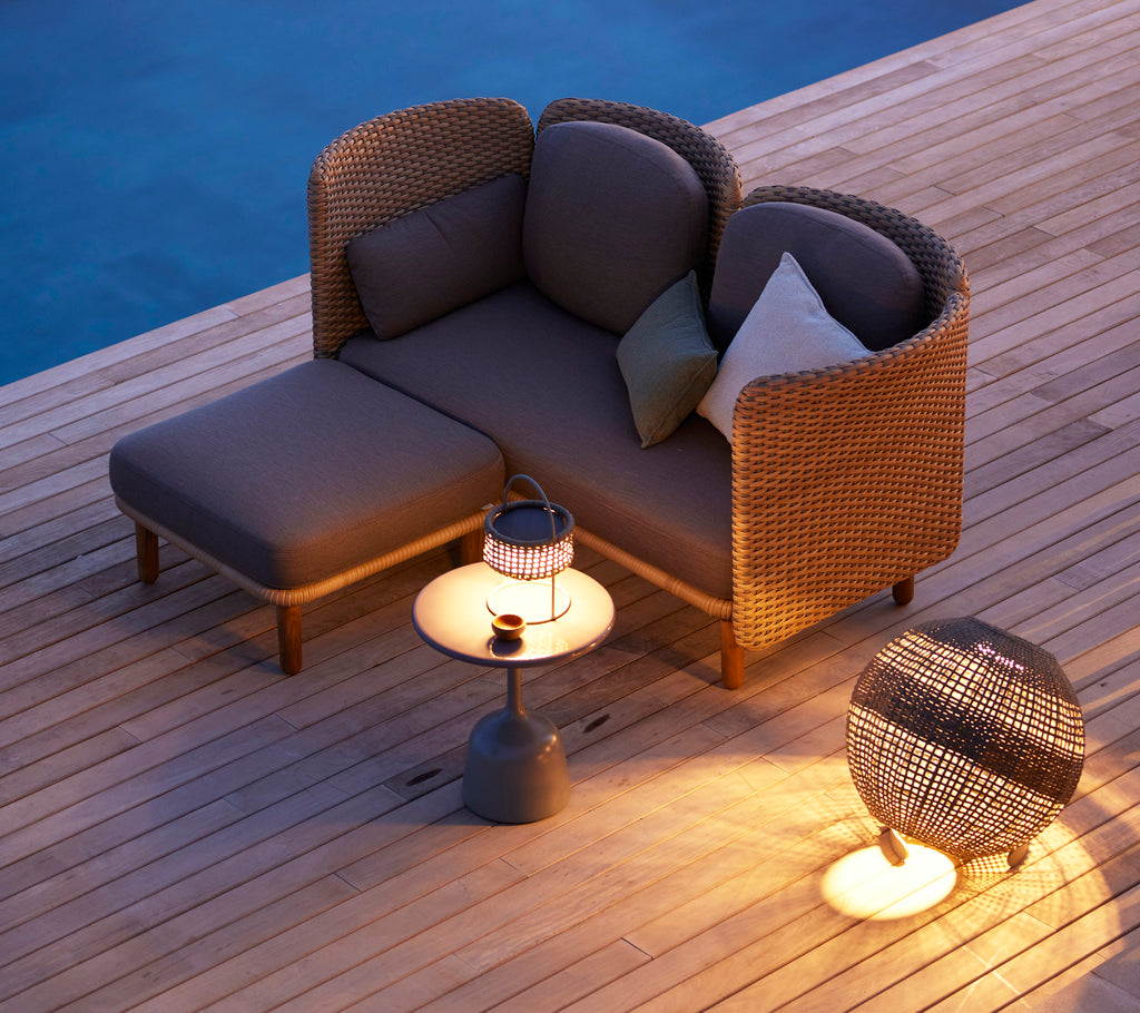 Cozy seating area featuring a stylish illusion lamp on a round side table and modern accent furniture, illuminated warmly in soft lighting.