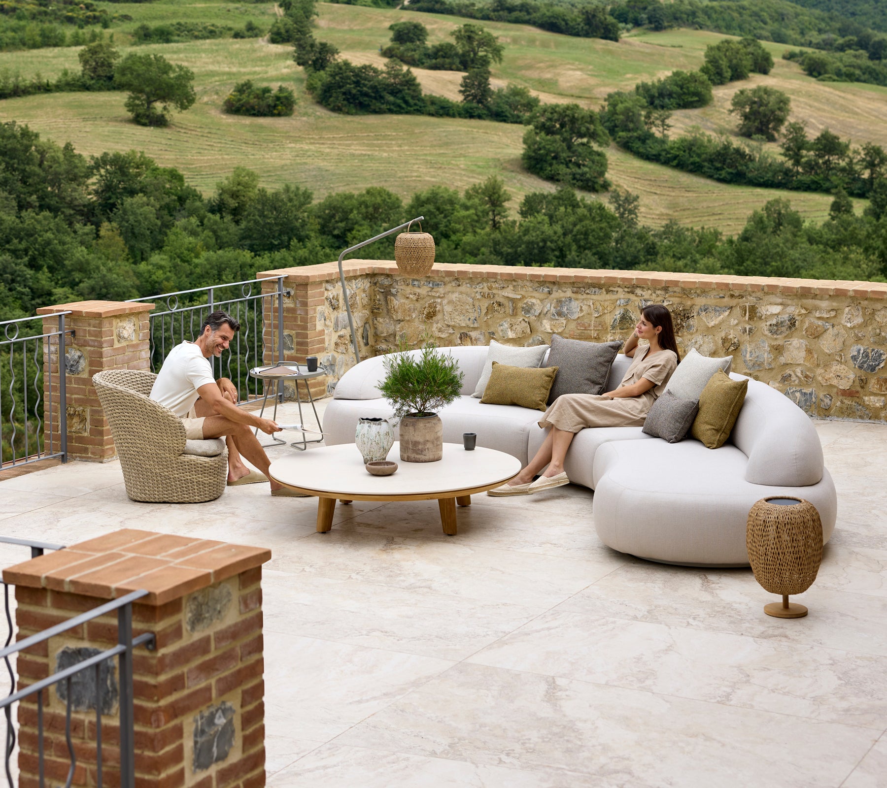 Relaxing seating arrangement featuring a mellow lounge sofa, Coast lounge chair, Aspect coffee table, and Illusion Glow accents with a scenic backdrop.