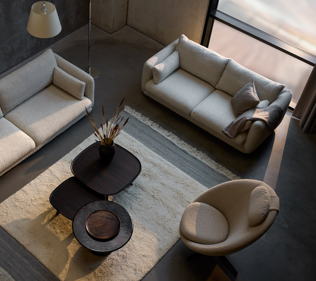 Modern living room featuring Pace in taupe scent and Bloom sofa group, accented by a round chair and stylish coffee tables.
