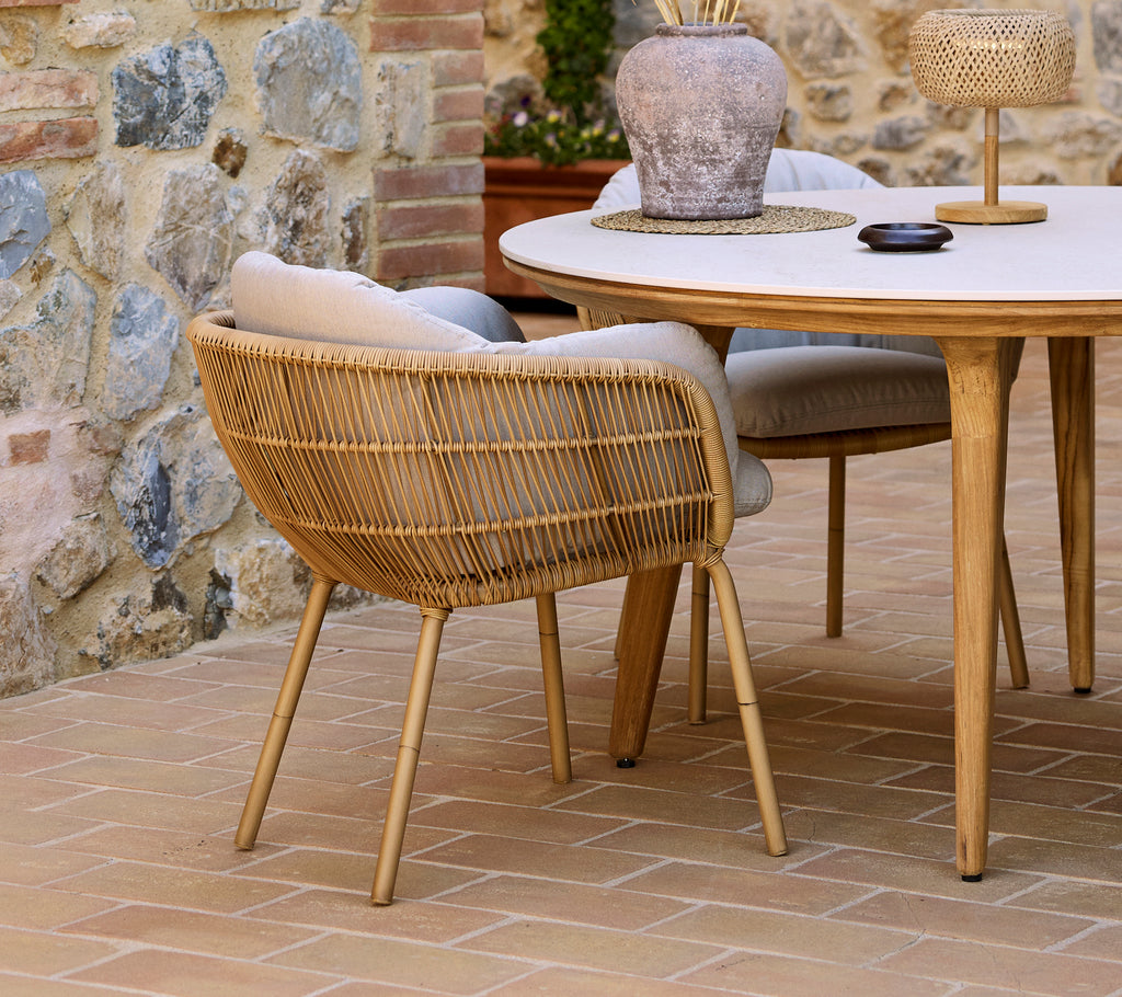 A stylish Stay dining chair with aluminum legs complements an elegant Aspect dining table, surrounded by decorative elements.